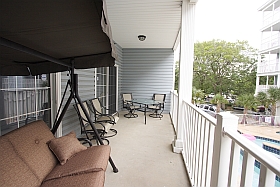 Ocean Blue Vacation Condo, Myrtle Beach - Lower Balcony with three person swing, table, four chairs
