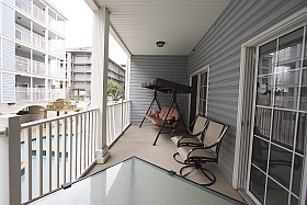 Ocean Blue Vacation Condo, Myrtle Beach - Lower Balcony with three person swing, table, four chairs